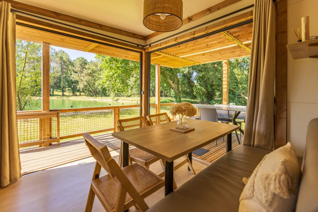 Chalet avec terrasse et vue sur l'étang à Gaia Ecolodge, hébergement nature en Dordogne près de Bergerac
